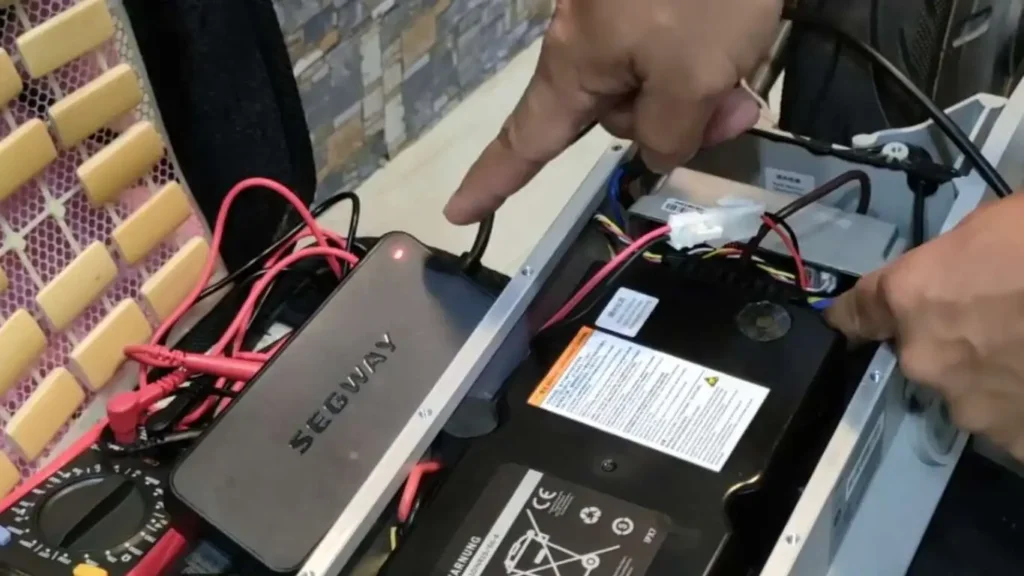 Man checking connection between ninebot battery and charging port